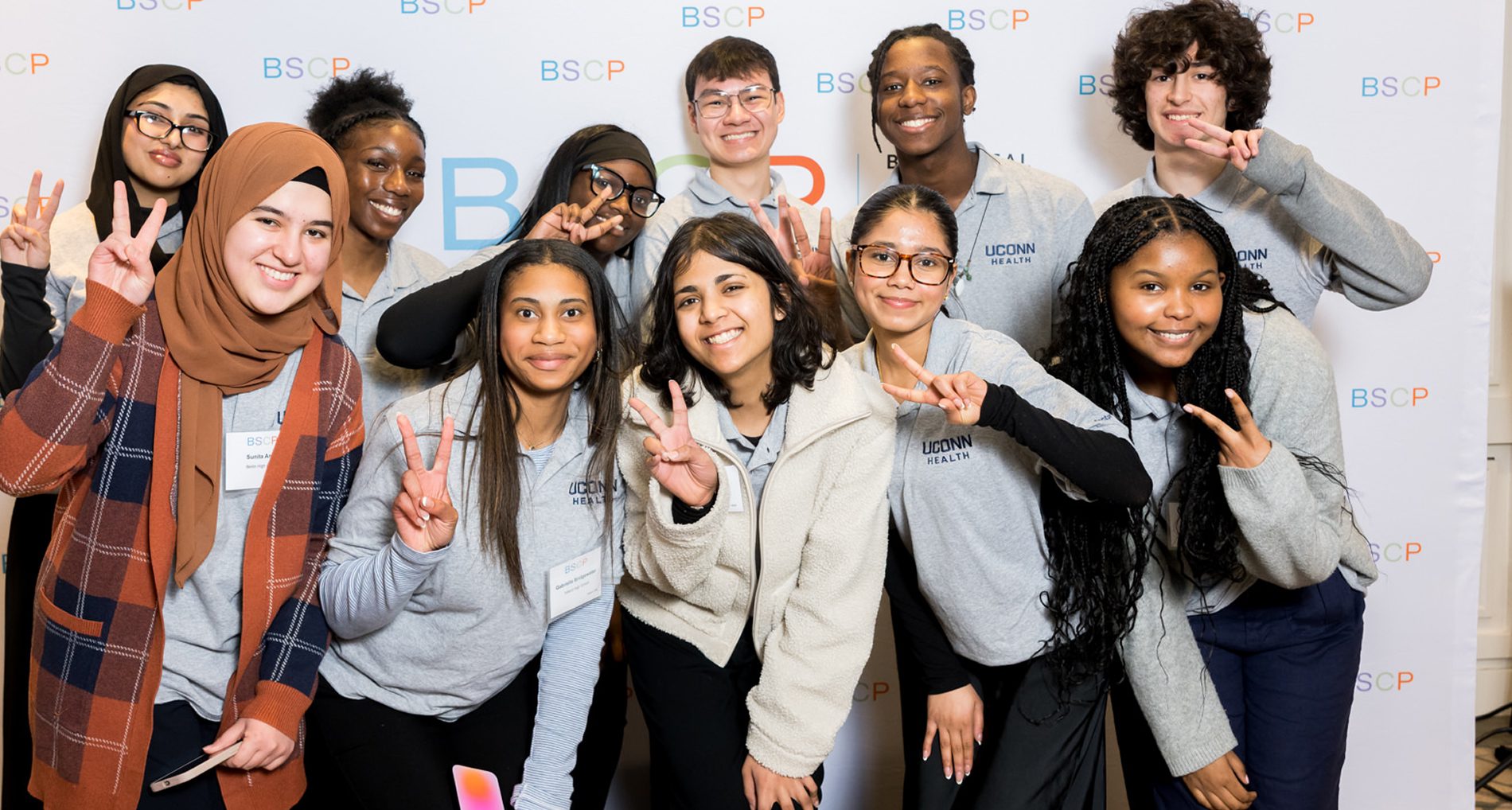 large multiracial group of students giving the peace sign