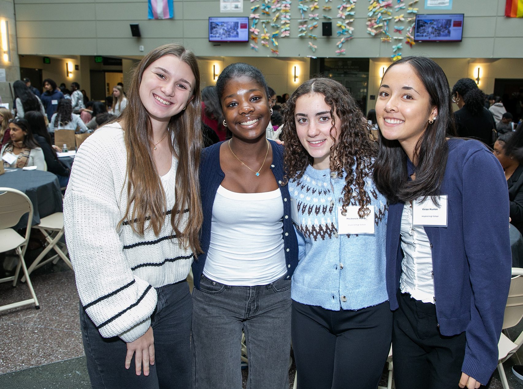 four students arm and arm smiling at camera