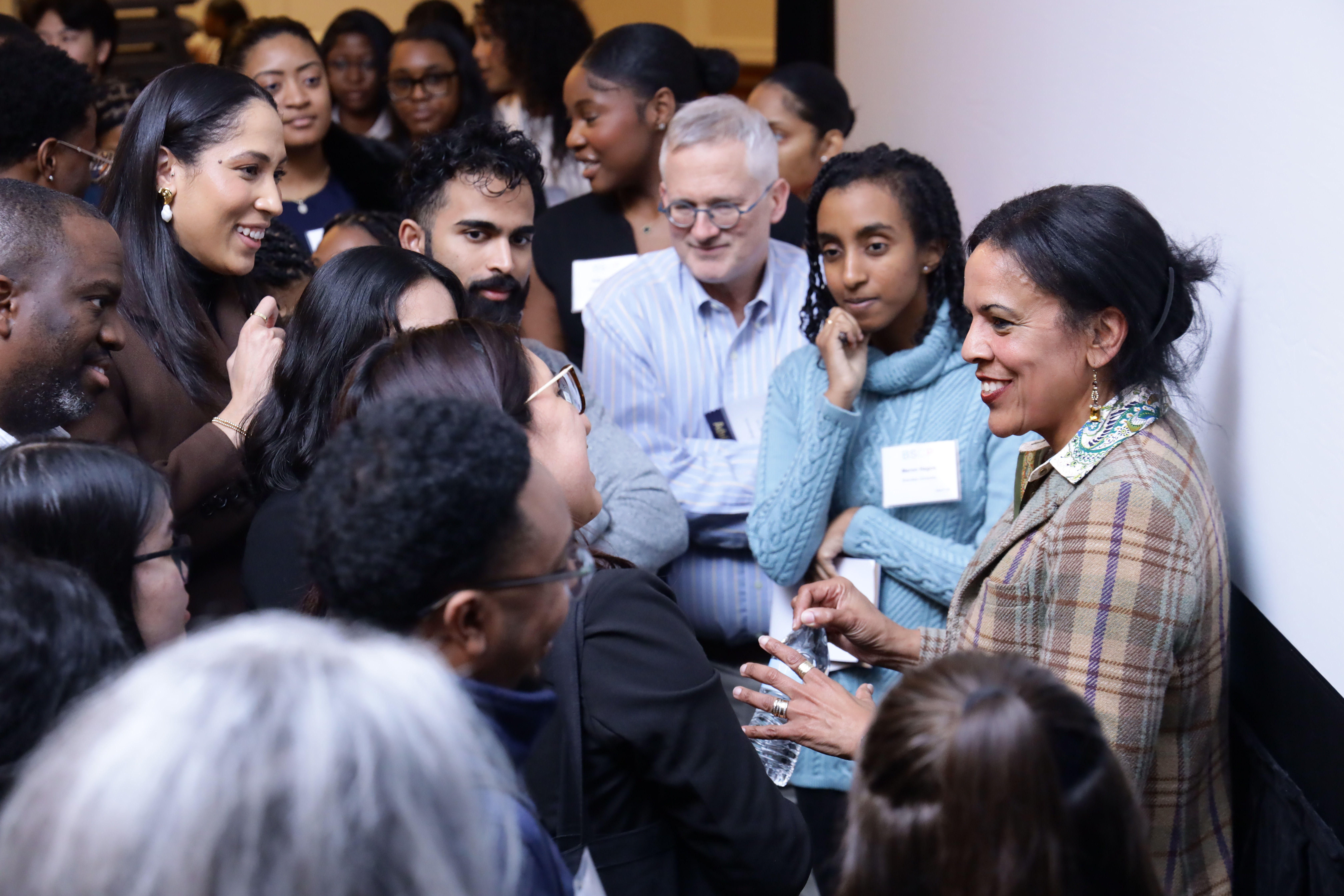 group of students gather around keynote speaker after speech
