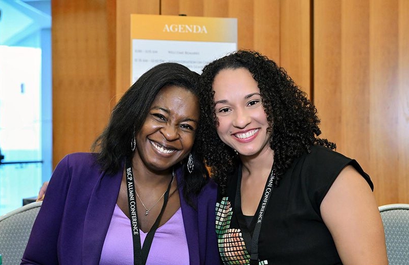 alumni conference 2024 two women leaning into each other and smiling at camera