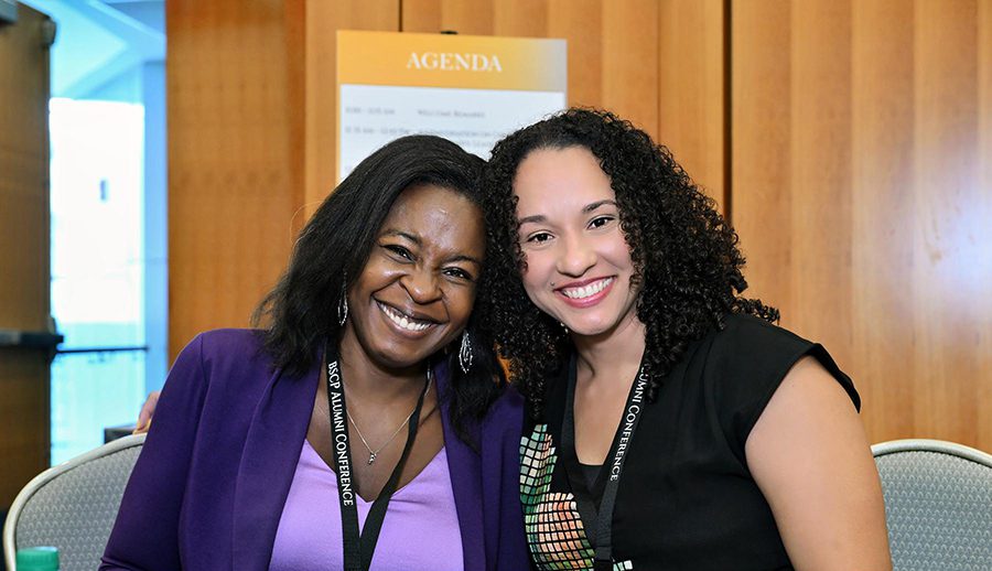 alumni conference 2024 two women leaning into each other and smiling at camera