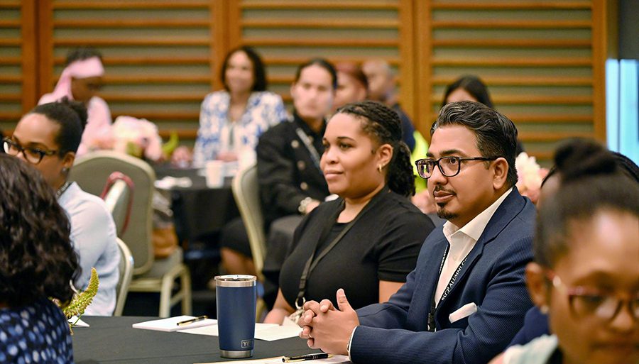 group of alumni looking forward in room full of people